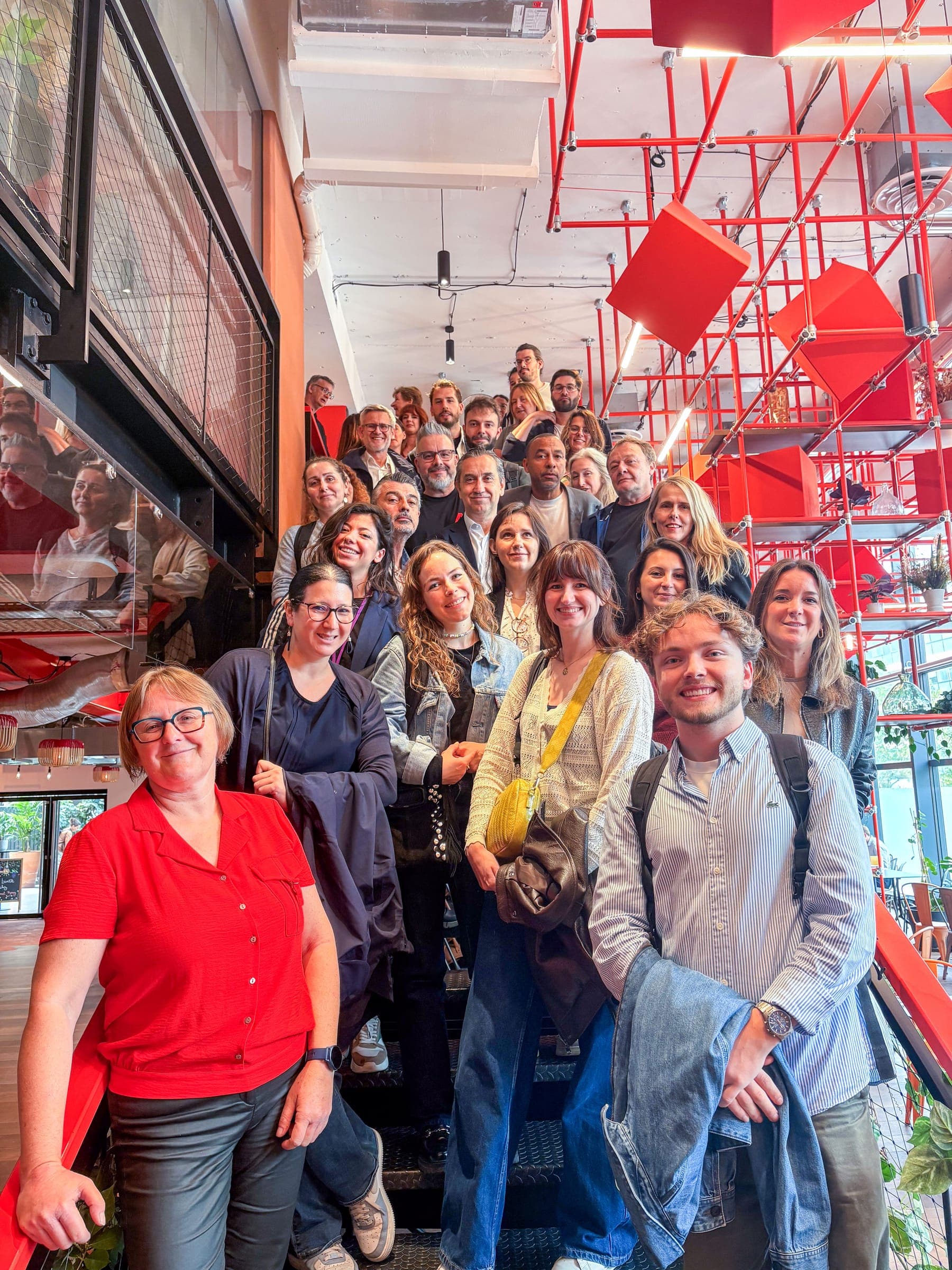 Group photo of the workshop participants on a staircase with red cubes. Victor is in the front row, on the right.