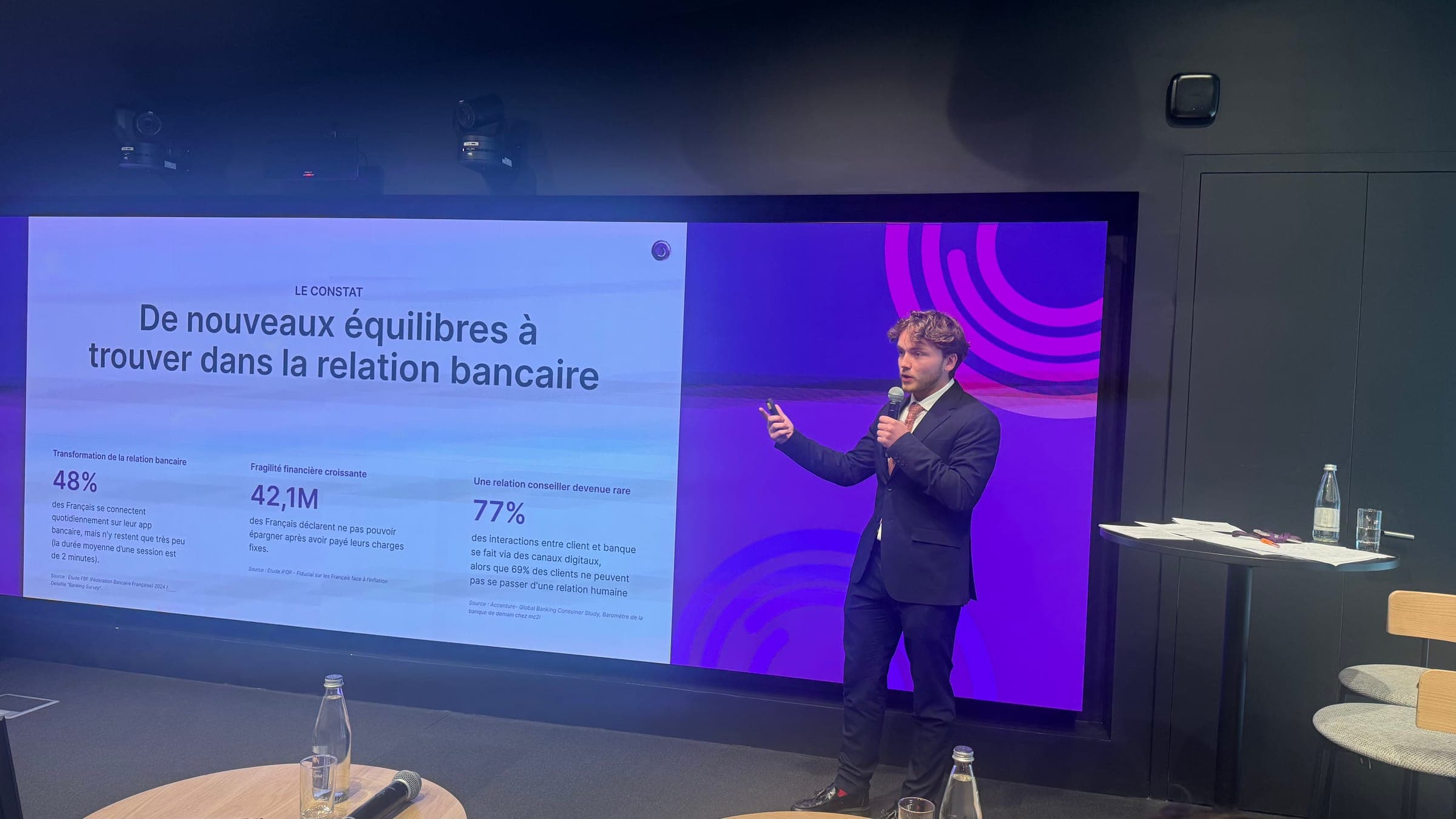 Victor alone on stage, mic in hand, in front of the slide "The finding: new balances to strike in the banking relationship".